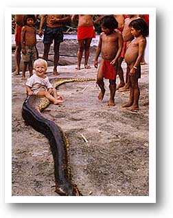 Missionary Kid sitting on dead anaconda snake. Photo copyright by T. Hill.